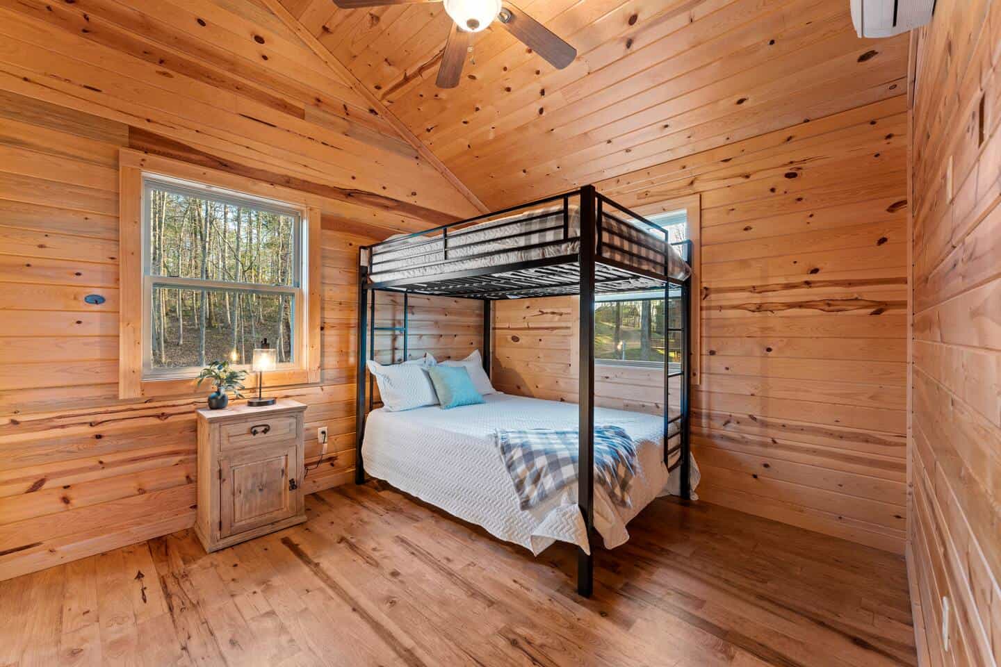 Rustic cabin bedroom with bunk bed and wooden interior, perfect for retreat stays.