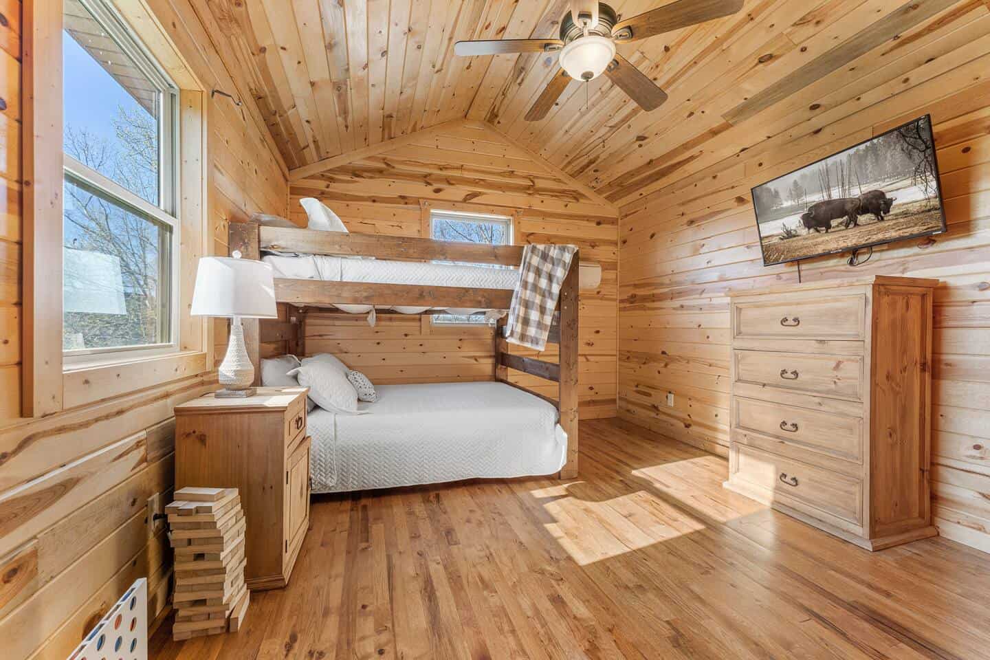 Comfortable rustic bedroom with bunk beds in a wooden cabin.