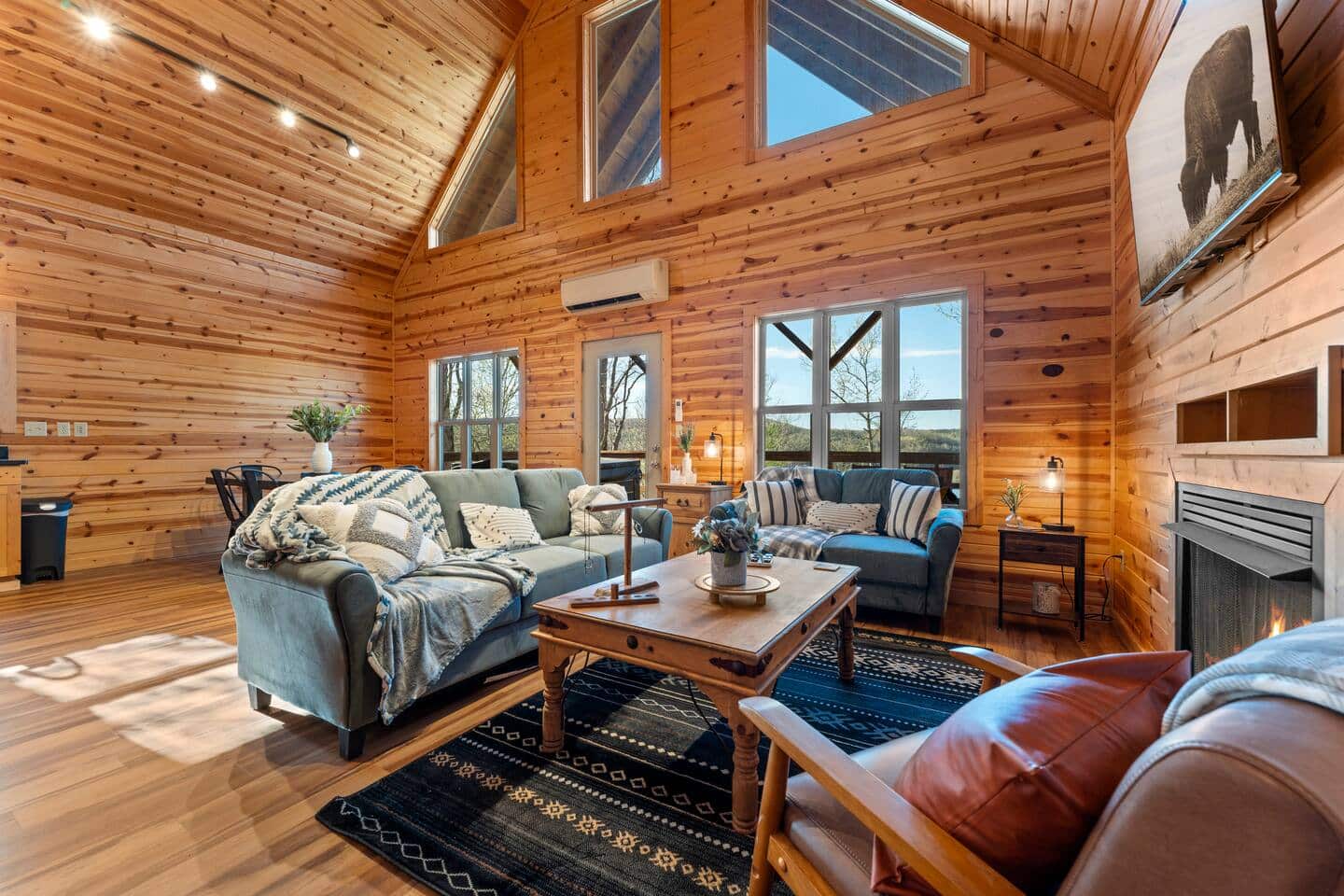 Cozy wooden cabin living room with large windows, comfortable sofas, and warm lighting, perfect for.
