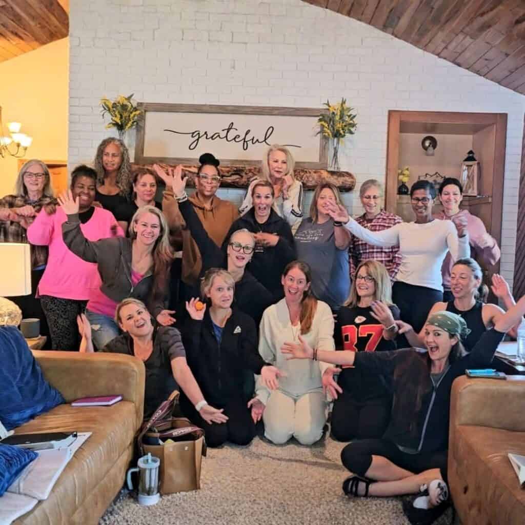Group of women celebrating at a healing retreat, smiling and enjoying each other's company.
